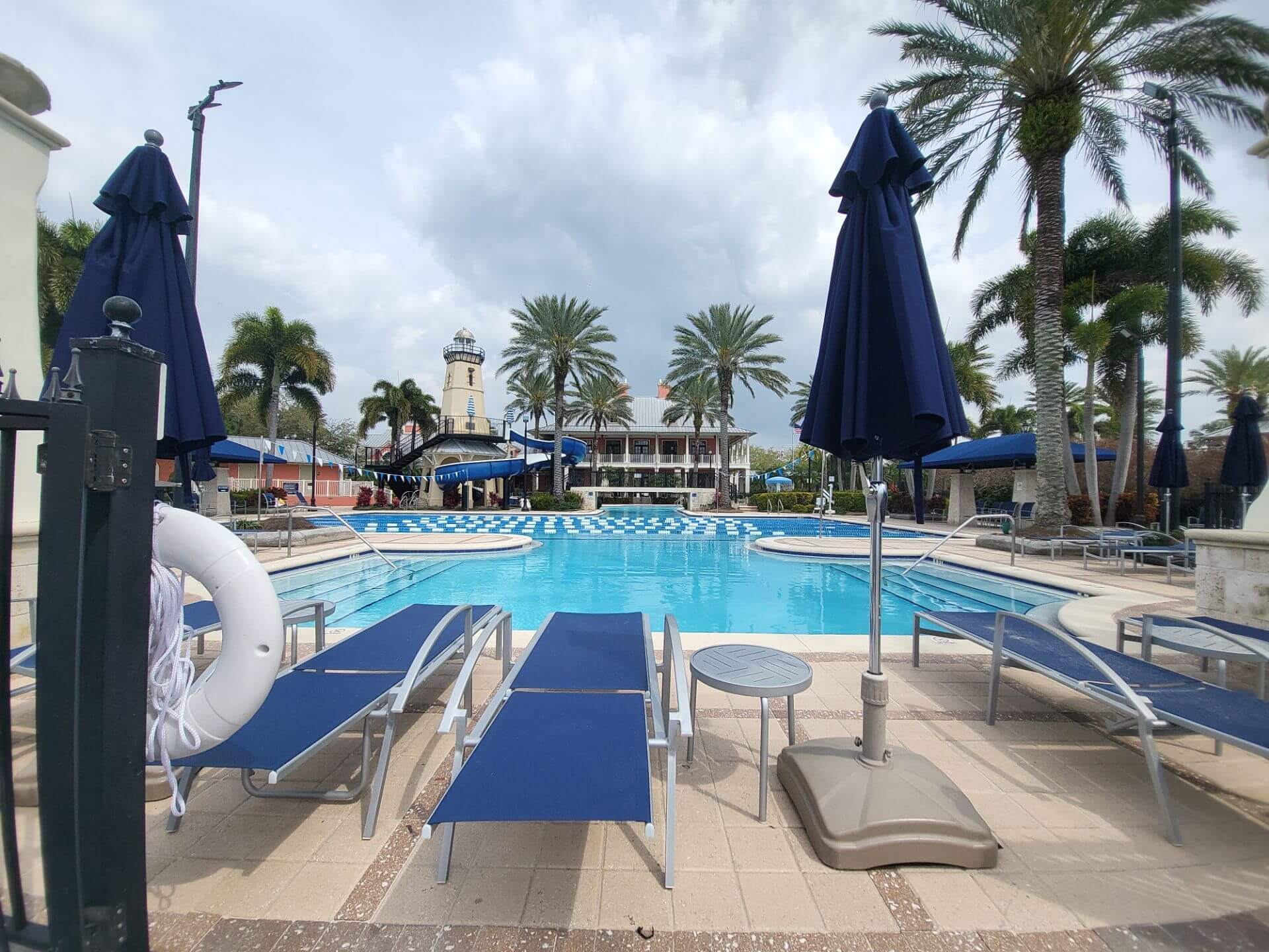 pool deck with chais and palm trees